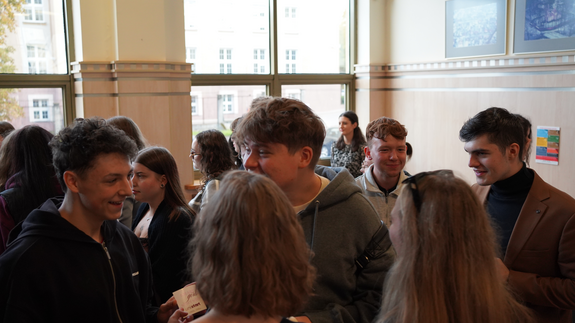 Na zdjęciu znajduje się grupa studentów na korytarzu uczelni czekająca na rozpoczęcie się szkoleń.